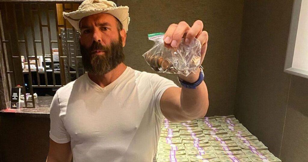 Dan Bilzerian posing in front of stacks of money