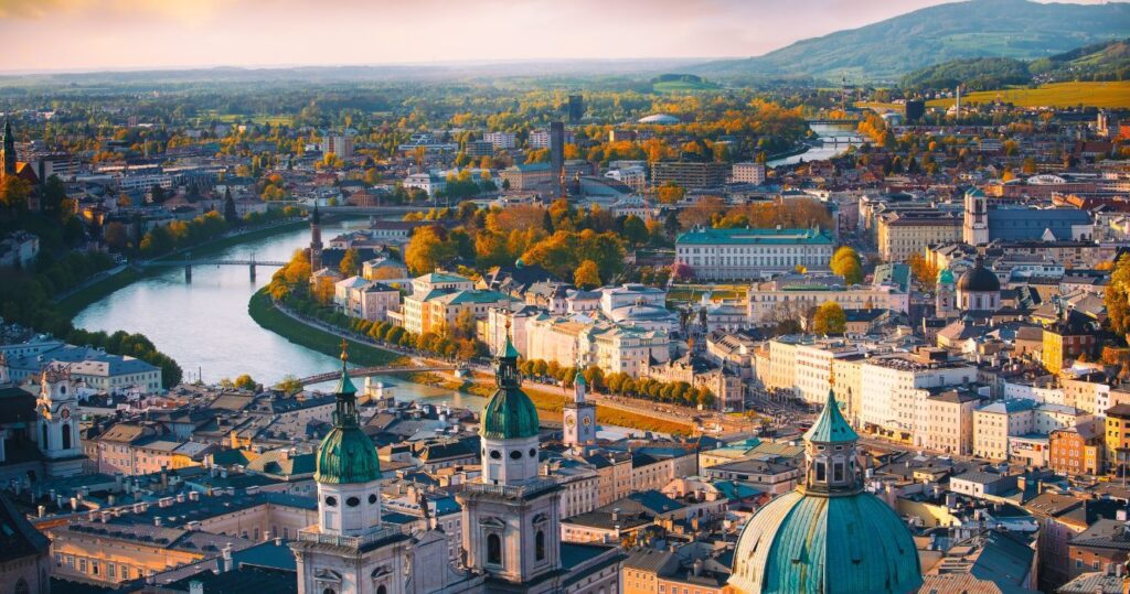 an aerial view of the city of vienna with the river and mountains in the background