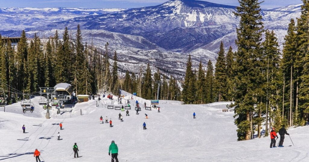 a crowded ski slope in the colorado mountains