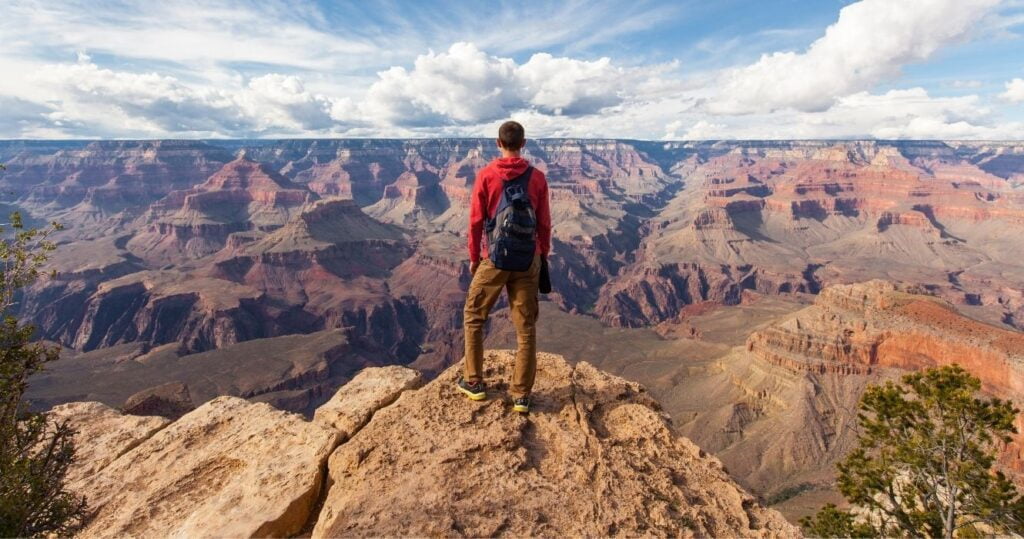 a hiker looking out over the grand canyon