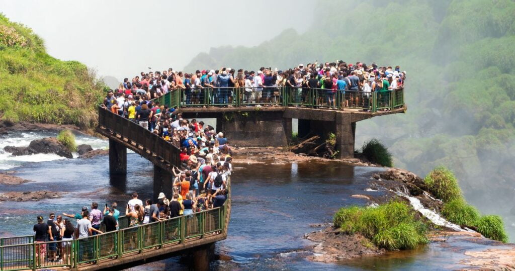 tourists crowded on iguasso bridge in brazil, overtourism